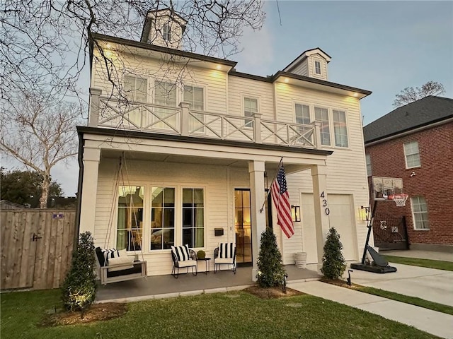 rear view of property with a porch, a balcony, and fence