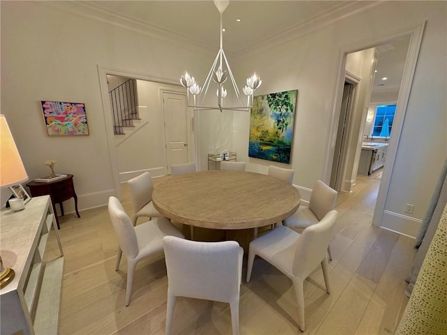 dining room with light wood-type flooring, stairway, ornamental molding, and a chandelier