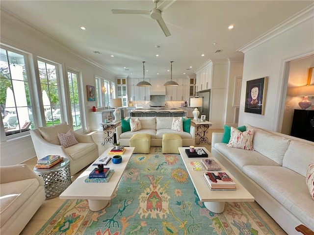 living area with recessed lighting, ornamental molding, and ceiling fan