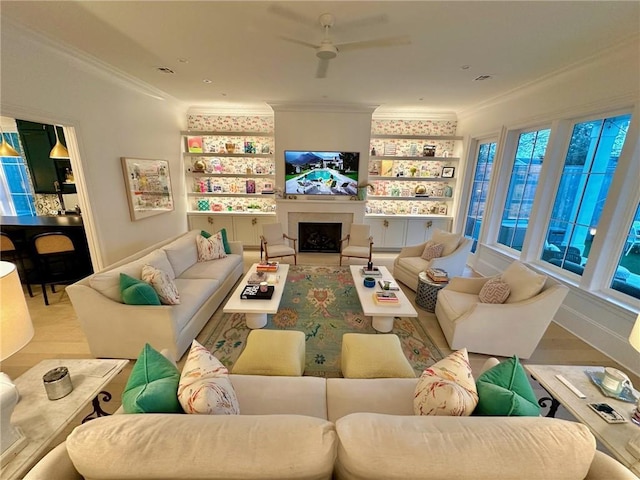 living area featuring wood finished floors, a fireplace, and ornamental molding