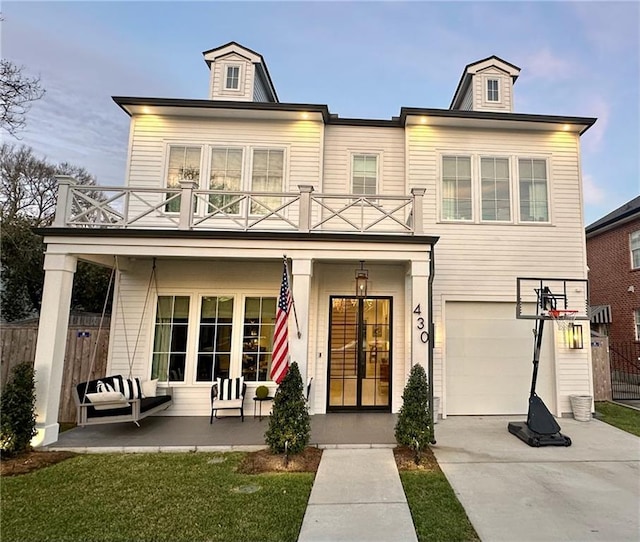 view of front facade with a balcony, fence, a porch, concrete driveway, and a garage