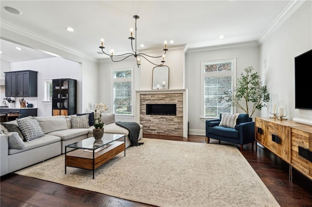 living room featuring an inviting chandelier, dark wood-style floors, a fireplace, and ornamental molding