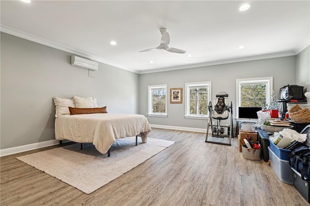 bedroom with baseboards, an AC wall unit, wood finished floors, and crown molding