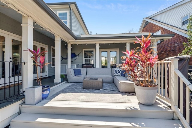 wooden deck featuring an outdoor living space and french doors