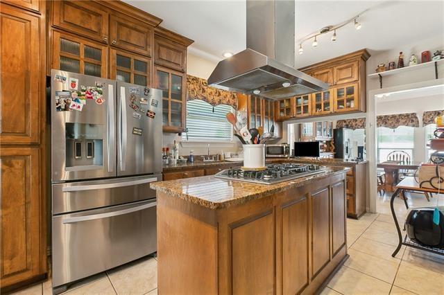 kitchen with brown cabinets, a center island, stainless steel appliances, island range hood, and glass insert cabinets