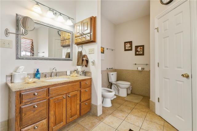 bathroom with tile patterned flooring, vanity, toilet, and a bidet