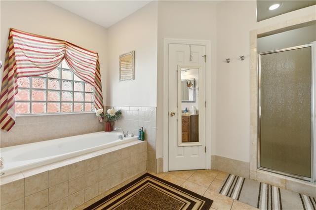 bathroom with tile patterned floors, a garden tub, and a stall shower