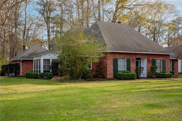 view of front of house with brick siding and a front lawn