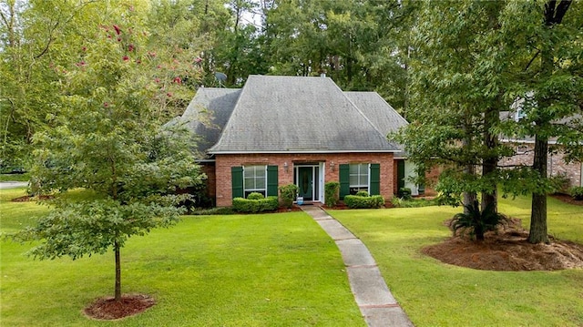 cape cod house with brick siding and a front lawn