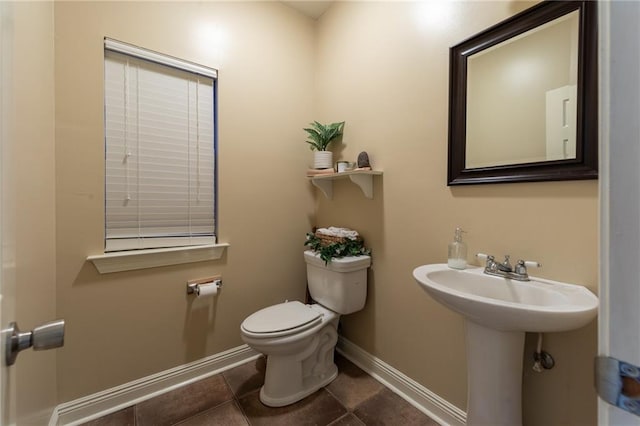 bathroom featuring tile patterned floors, toilet, and baseboards