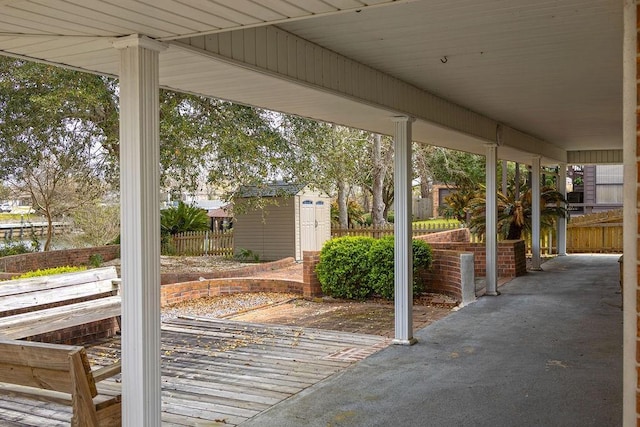 view of patio with fence, an outbuilding, and a shed