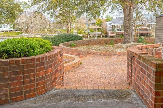 exterior space featuring a patio area, fence, and a water view