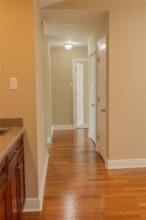 hall with light wood finished floors and baseboards