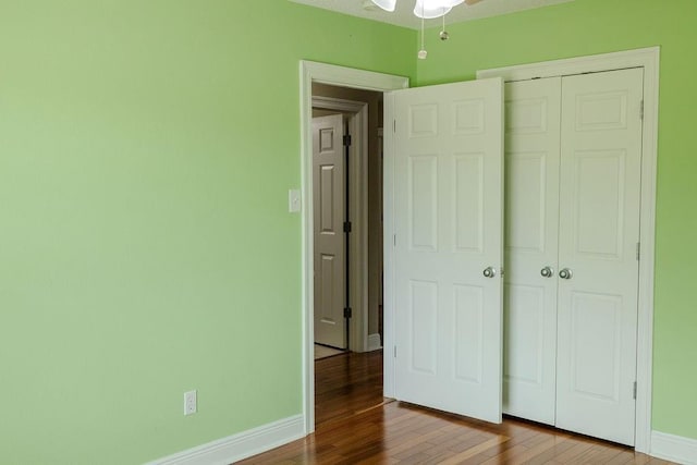 unfurnished bedroom with baseboards, a closet, and wood-type flooring