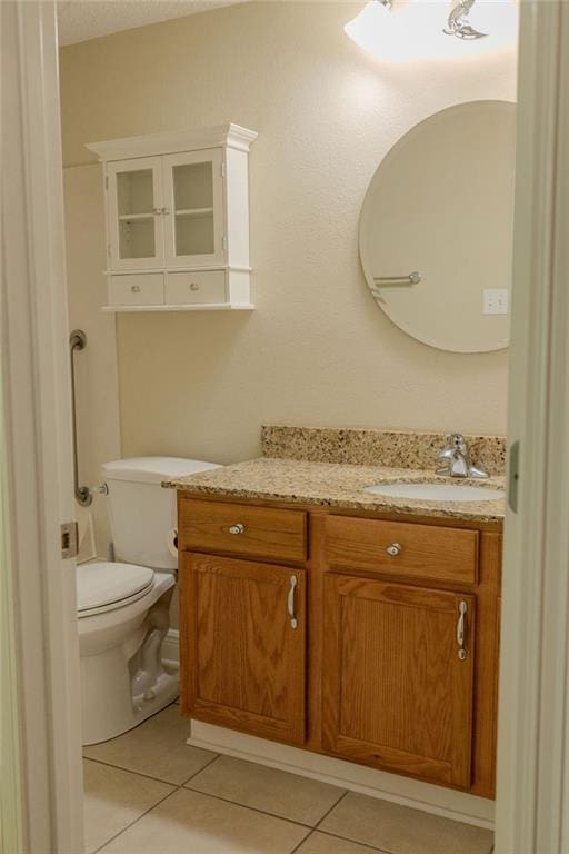 half bath featuring tile patterned floors, toilet, and vanity