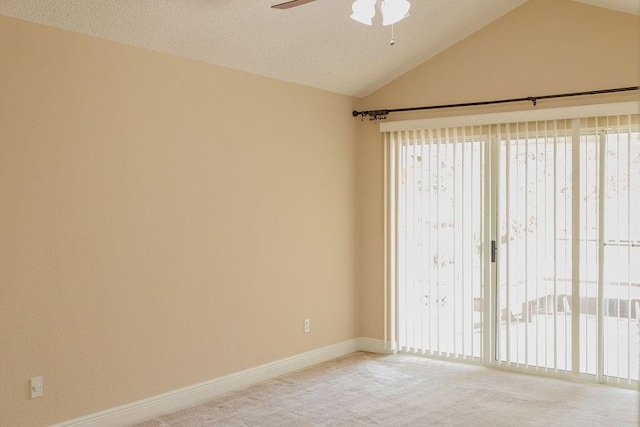 empty room with vaulted ceiling, baseboards, carpet floors, and ceiling fan