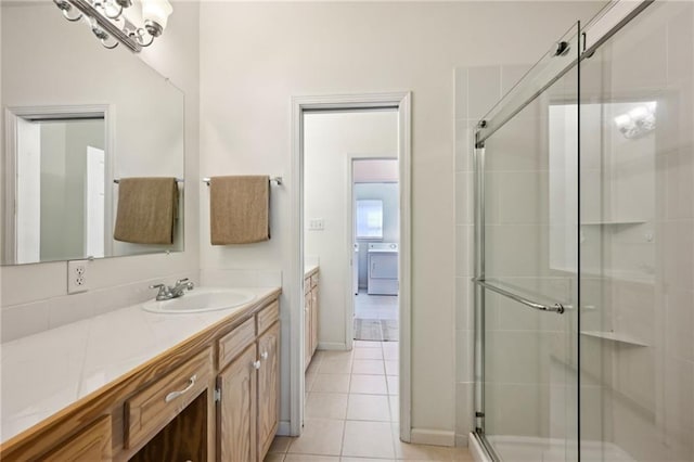 full bath featuring tile patterned flooring, washer / clothes dryer, a stall shower, and vanity