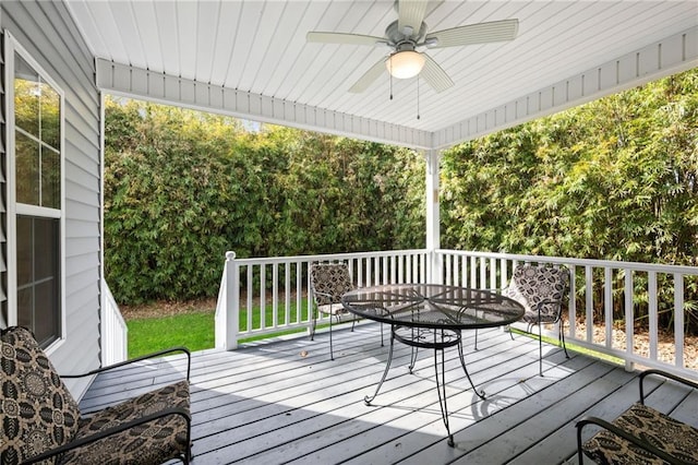 deck with outdoor dining area and a ceiling fan