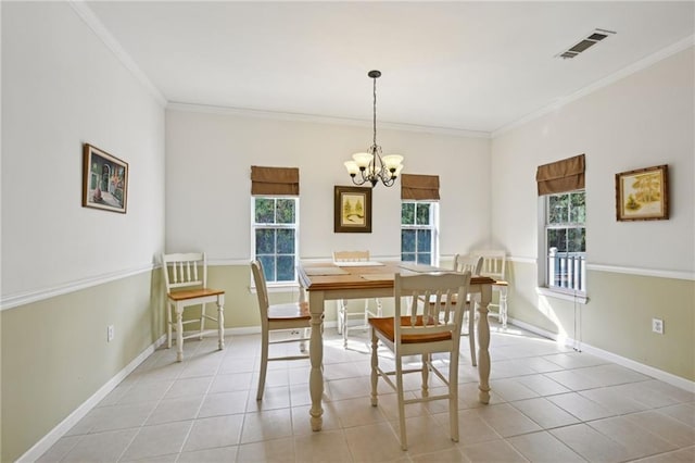 dining room featuring a notable chandelier, baseboards, crown molding, and visible vents