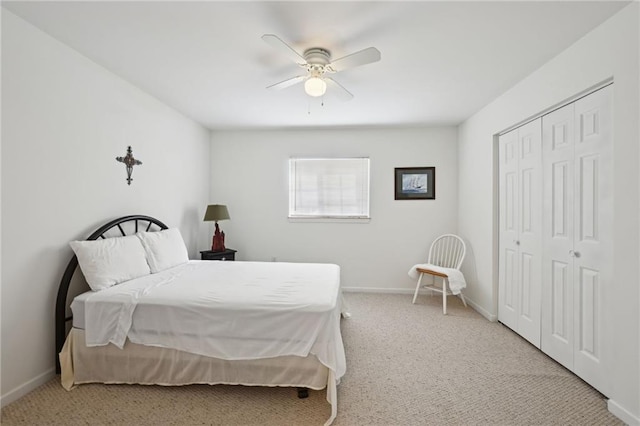 carpeted bedroom featuring a closet, ceiling fan, and baseboards