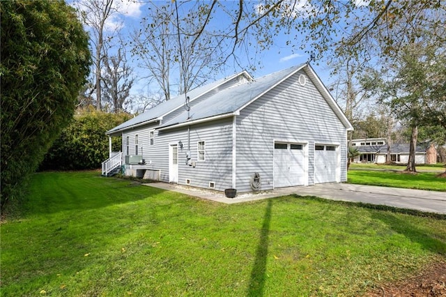 view of side of home featuring concrete driveway and a lawn