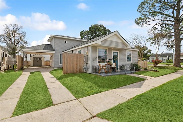 view of front of house featuring an outbuilding, a storage unit, a front yard, and fence