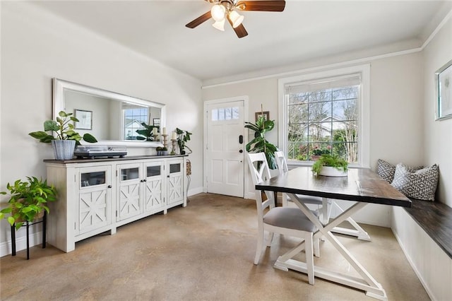 interior space with baseboards, concrete floors, and a ceiling fan