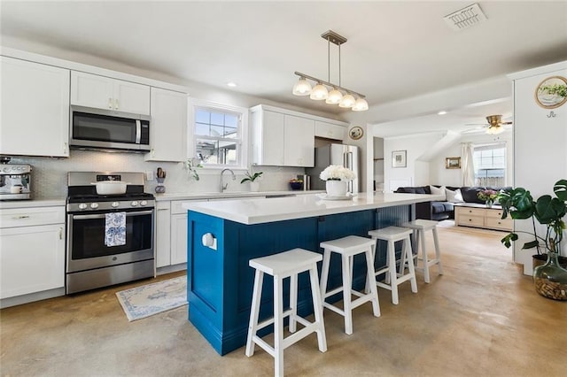 kitchen with stainless steel appliances, visible vents, decorative backsplash, and a healthy amount of sunlight