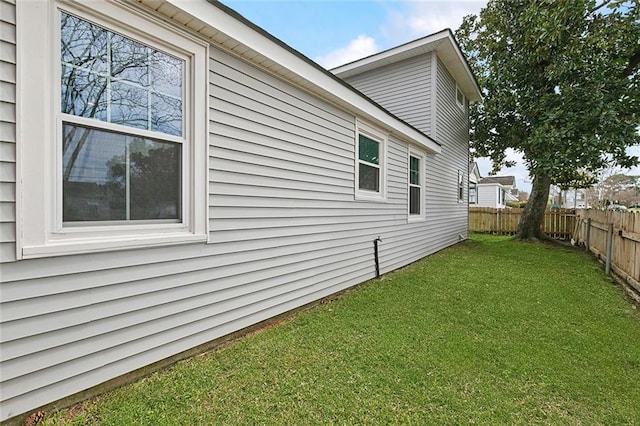 view of home's exterior with a yard and fence