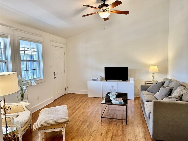 living room featuring ceiling fan, baseboards, and light wood-style floors