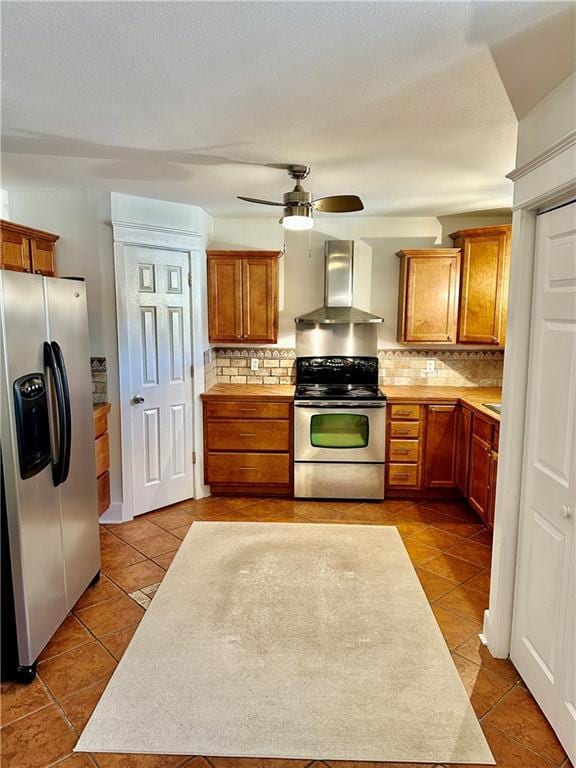 kitchen with decorative backsplash, tile patterned floors, wall chimney range hood, and stainless steel appliances