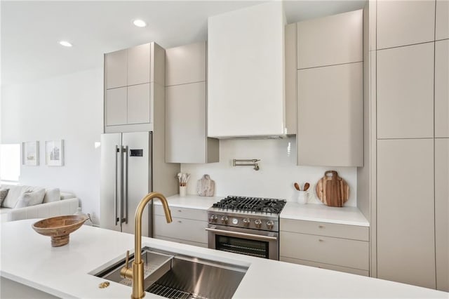 kitchen featuring a sink, modern cabinets, high quality appliances, and gray cabinetry