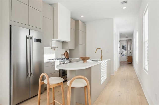 kitchen with visible vents, gray cabinetry, modern cabinets, a sink, and stainless steel appliances