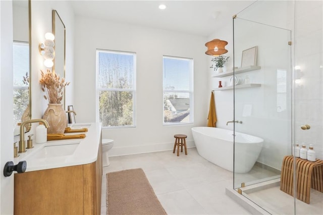 full bath with vanity, a soaking tub, a stall shower, tile patterned flooring, and toilet