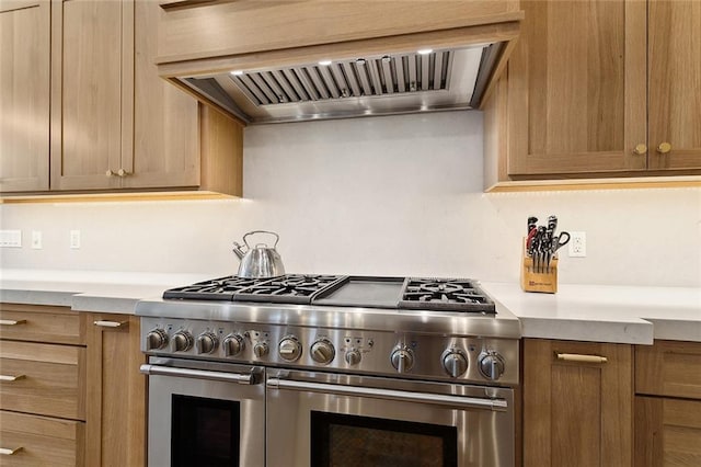 kitchen featuring premium range hood, light countertops, and range with two ovens