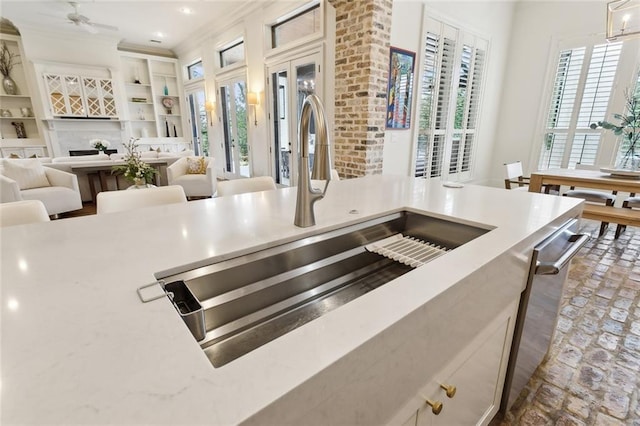 kitchen with a sink, dishwasher, open floor plan, and light countertops