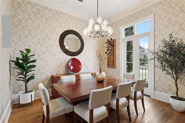 dining room featuring baseboards, hardwood / wood-style flooring, crown molding, and wallpapered walls