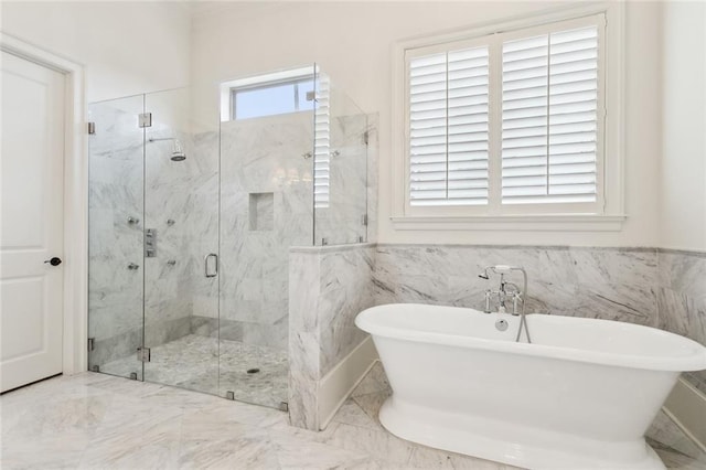 full bathroom featuring a marble finish shower, a wainscoted wall, a freestanding bath, and tile walls