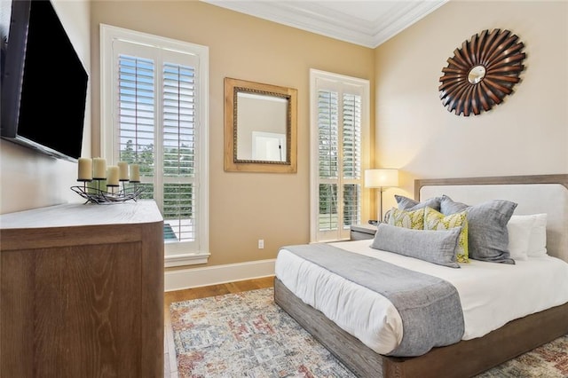 bedroom with baseboards, wood finished floors, and ornamental molding