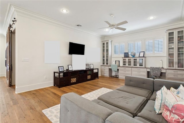 living area featuring a ceiling fan, ornamental molding, built in desk, and light wood finished floors