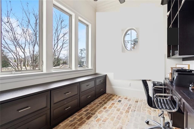 office space with baseboards, brick floor, and ornamental molding