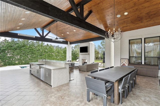 view of patio with outdoor dining space, a ceiling fan, an outdoor living space with a fireplace, a sink, and exterior kitchen