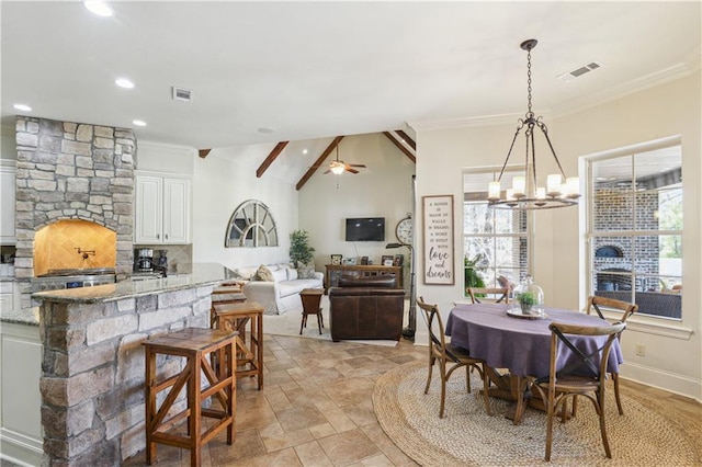 dining room with visible vents, ornamental molding, and a fireplace