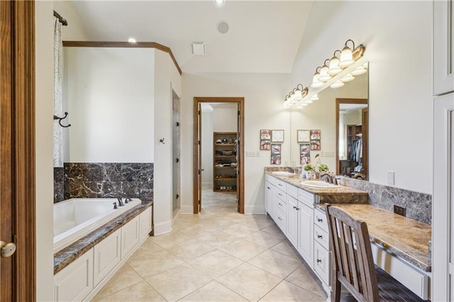 bathroom featuring lofted ceiling, a sink, tile patterned flooring, a walk in closet, and a bath