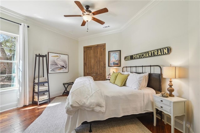 bedroom with visible vents, multiple windows, ornamental molding, and dark wood-style flooring