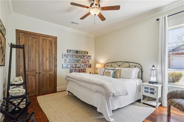 bedroom featuring ceiling fan, visible vents, ornamental molding, and dark wood-style flooring