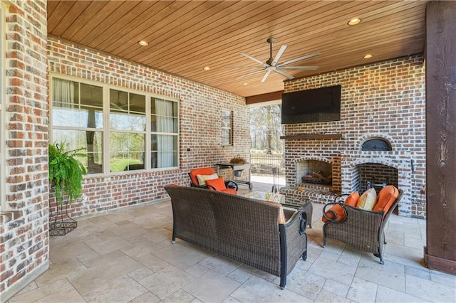 view of patio / terrace with an outdoor living space with a fireplace and ceiling fan