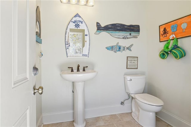 bathroom featuring baseboards and toilet