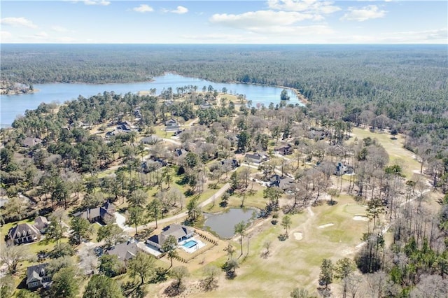 drone / aerial view with a forest view and a water view