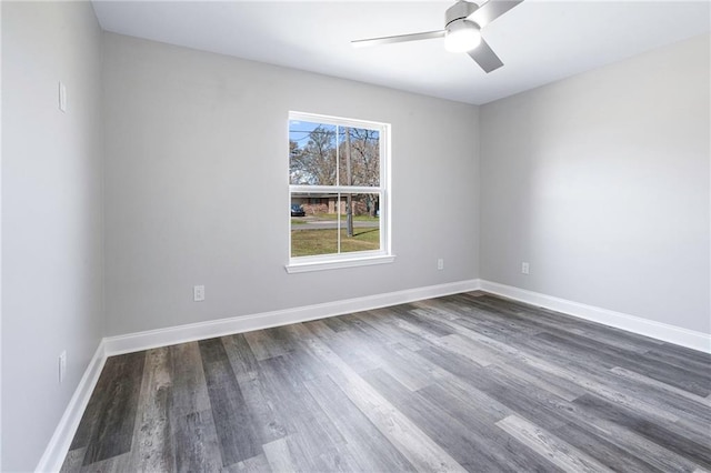 empty room featuring ceiling fan, baseboards, and dark wood finished floors